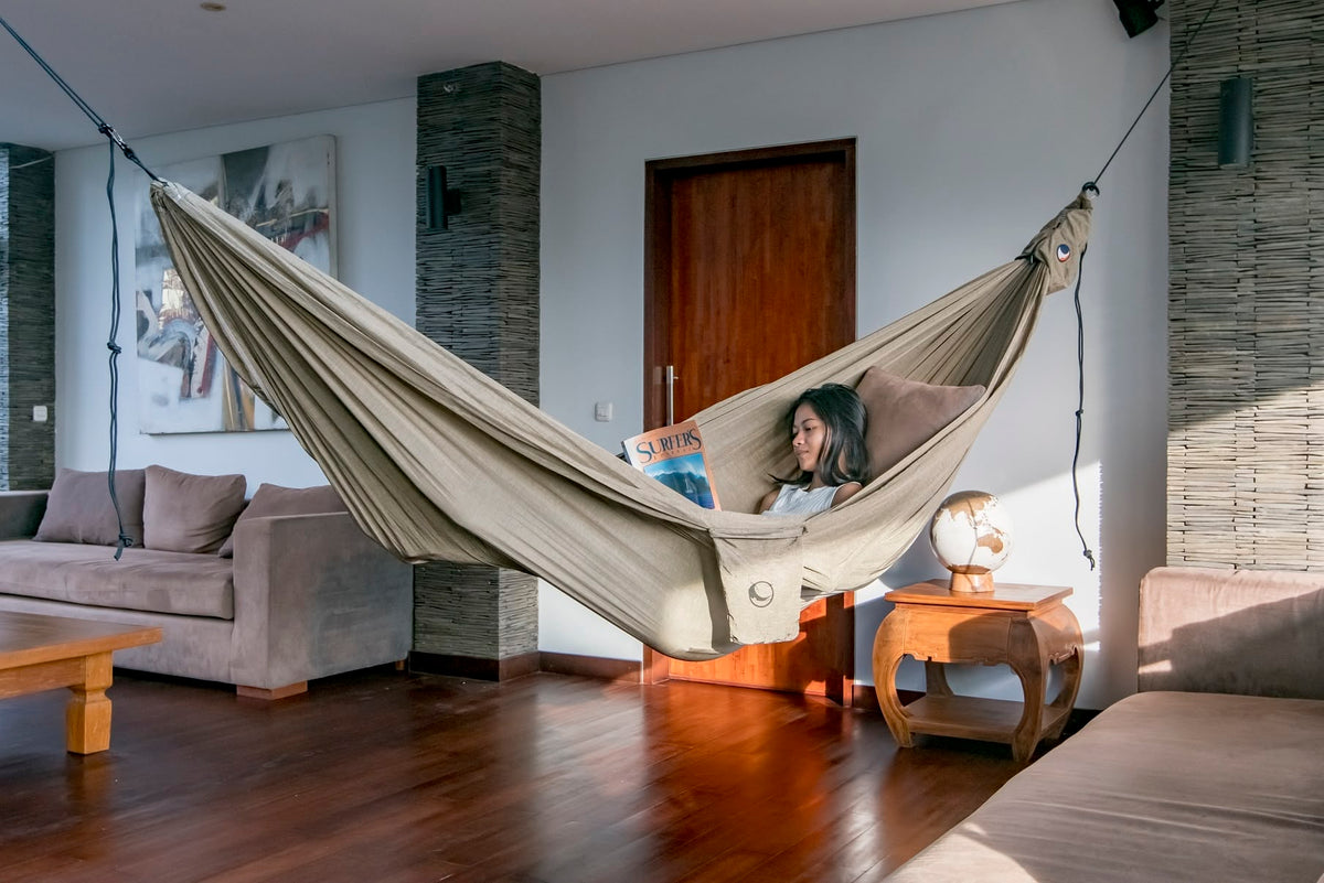 Woman reading a surf magazine in a Natural Beige Home Hammock 420 hung across a living room