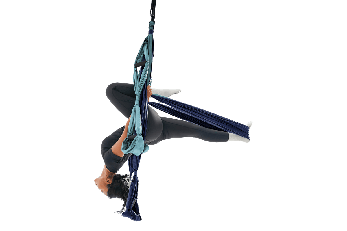 Woman hanging upside down in a Deep Blue and Ice Blue Yoga Hammock, holding the handles with her legs extended